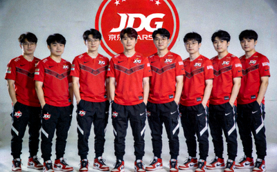 JDG京东电子竞技俱乐部英雄联盟分部全体队员合影 - 红色队服，背景为JDG Logo